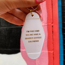 Load image into Gallery viewer, I'm Poly and Yes We Have a Shared Google Calendar Motel Style Keychain in White and Gold | Polyamory Themed Funny Key Tag
