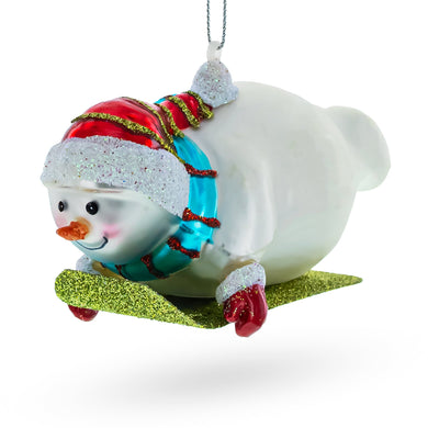 Snowman Gleefully Riding a Sled Glass Christmas Ornament