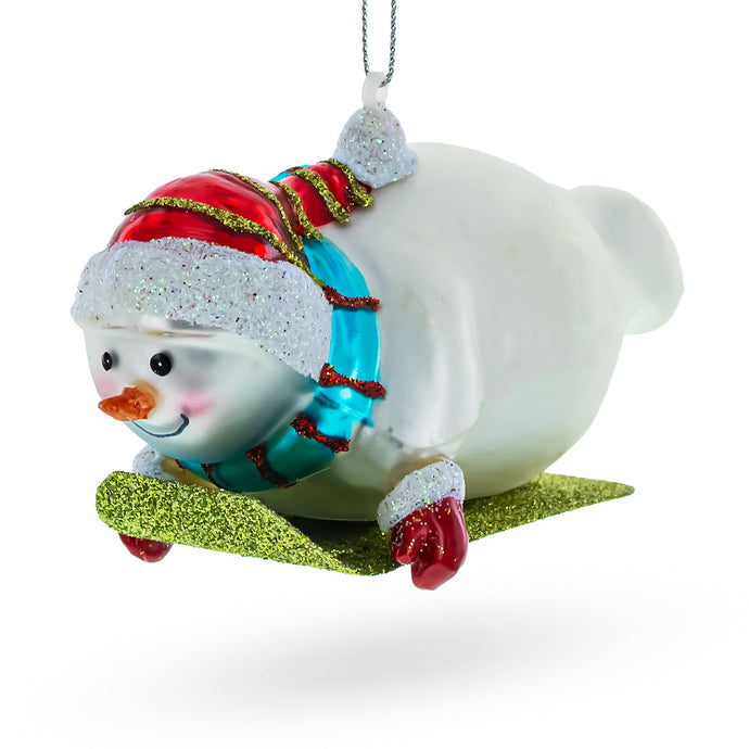 Snowman Gleefully Riding a Sled Glass Christmas Ornament
